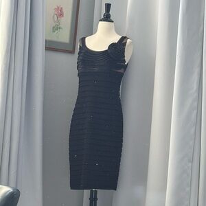 Beautiful black cocktail dress in black with ruffle and flower on bust detail